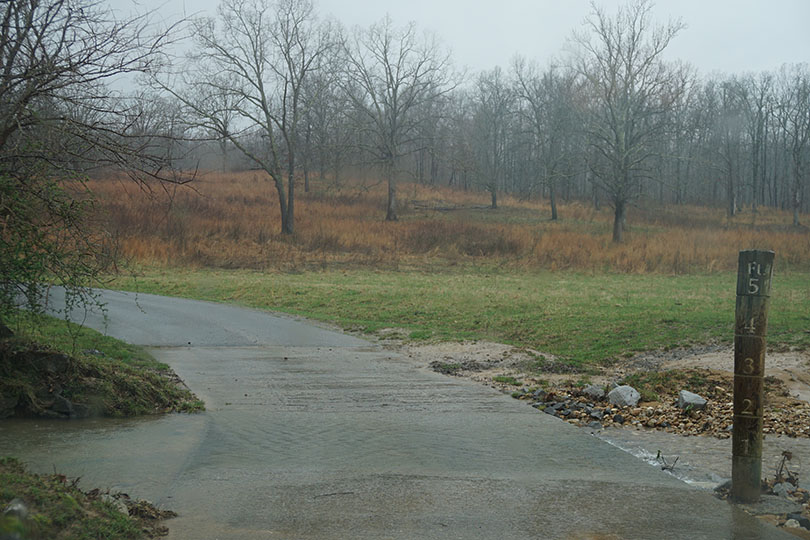 Water spilling over the road that needs to be crossed.